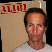 Sour-looking man with short dark hair in front of a manila folder stamped "Alibi"